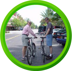 Two men standing on a roadway with their bikes and Spiderflex hornless saddles